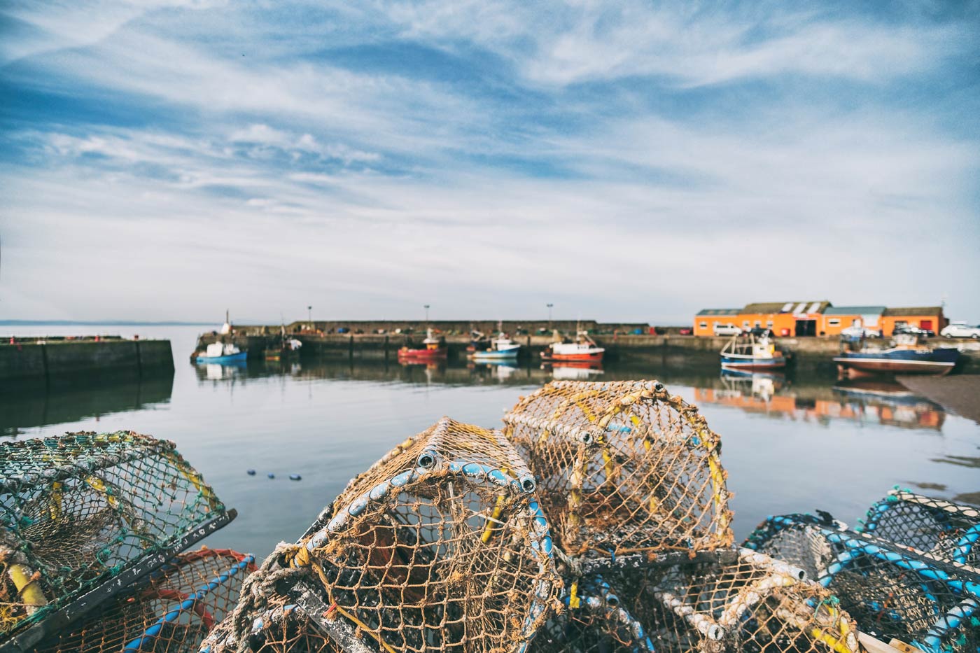 Lobster pots stacked onto each other in a small fishing port.
Port Seaton, Scotland, UK